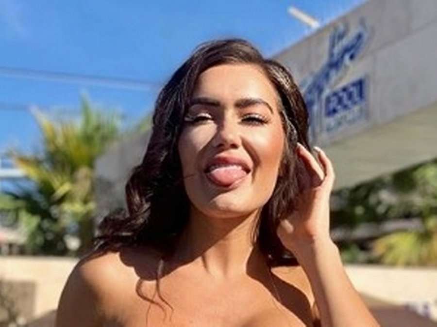 Modelja super-seksi pozon 99 % e zhveshur, pjesët intime i mbulon me copëza veshjesh