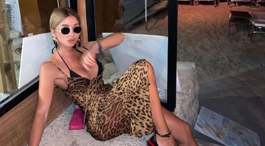 Aurela pozon joshëse para pasqyrës e veshur me fustan super të shkurtër