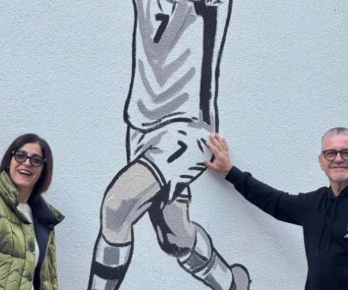 Moment krenarie – prindërit e Manajt në Mitrovicë, pozojnë me muralin e djalit të tyre 